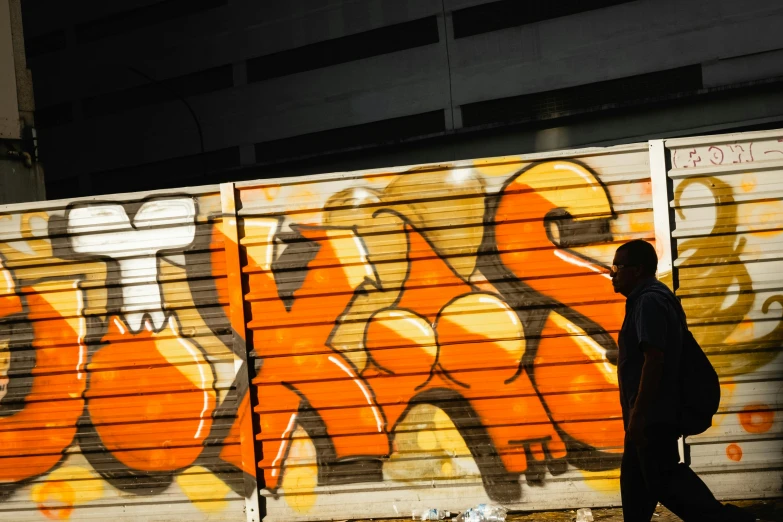 a man walking past a truck with some graffiti on it