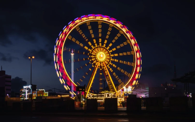 a ferris wheel lit up at night with a bright light