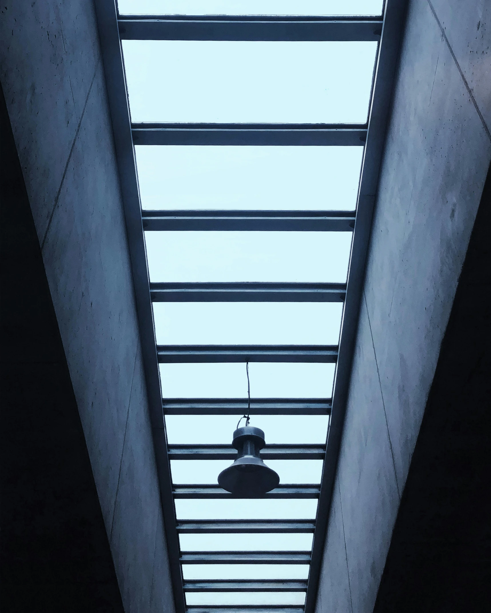 a light hanging from the ceiling in the middle of a building