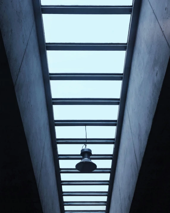 a light hanging from the ceiling in the middle of a building