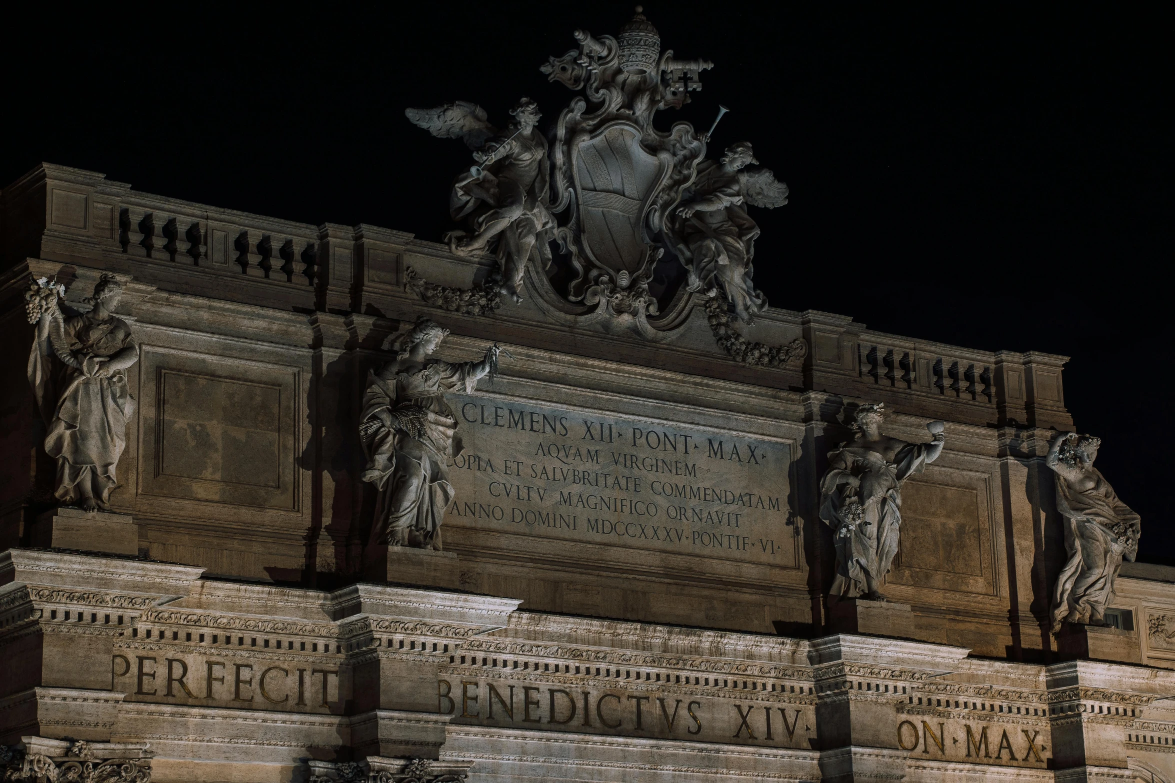 monument with statues on it at night, under the moon