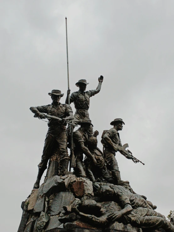 several statues stand on top of a monument