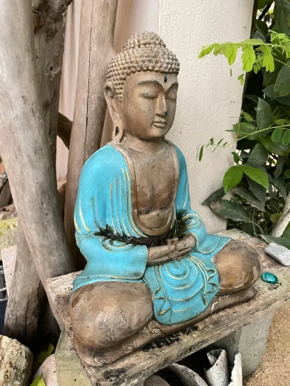 a statue of a buddha is sitting on a bench