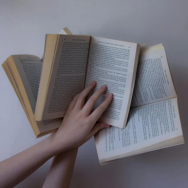 the two hands are holding an open book