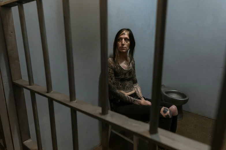 the woman is sitting on the floor in a  cell