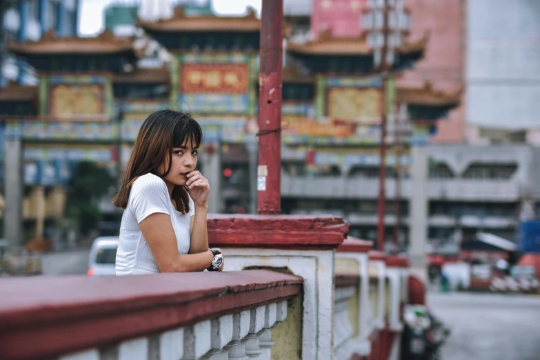 a girl leans against the wall near a building