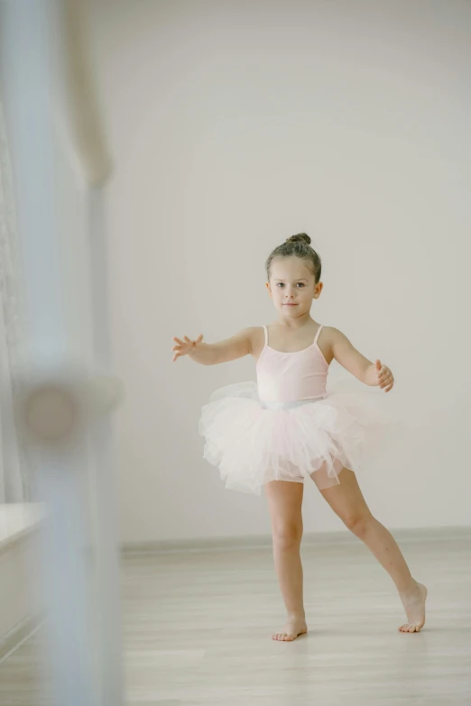 a little girl that is wearing a ballet outfit