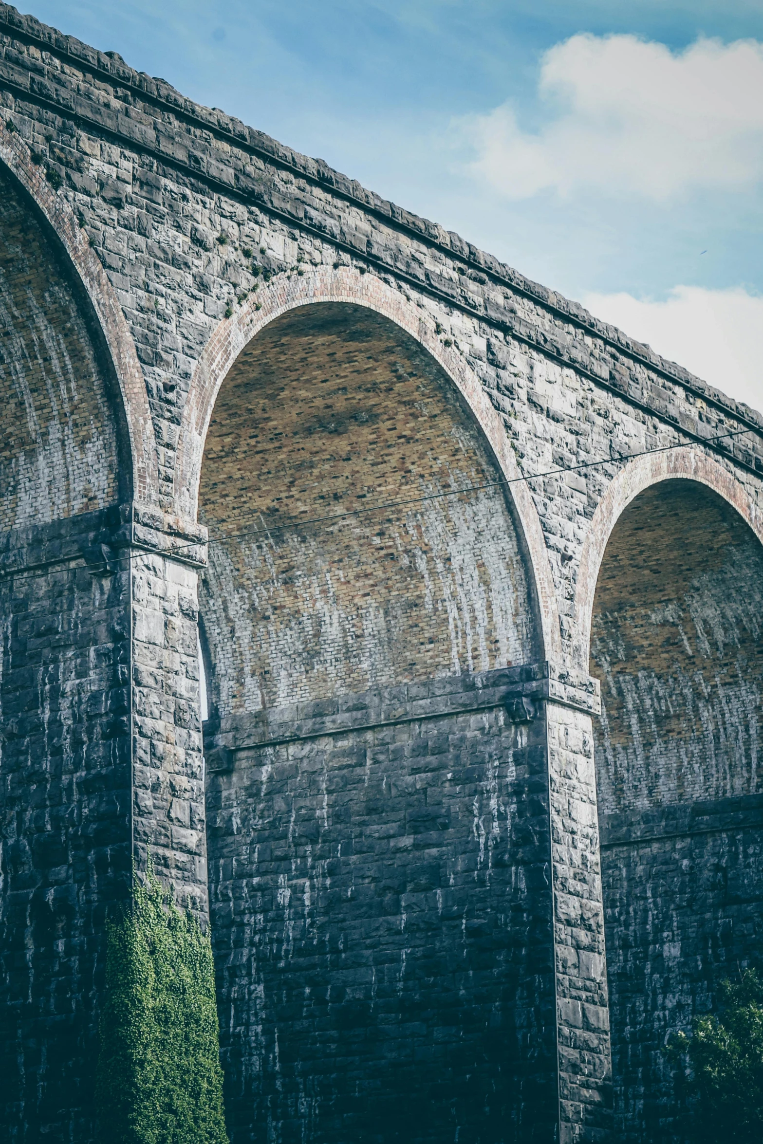 a train traveling over a bridge next to tall rocks