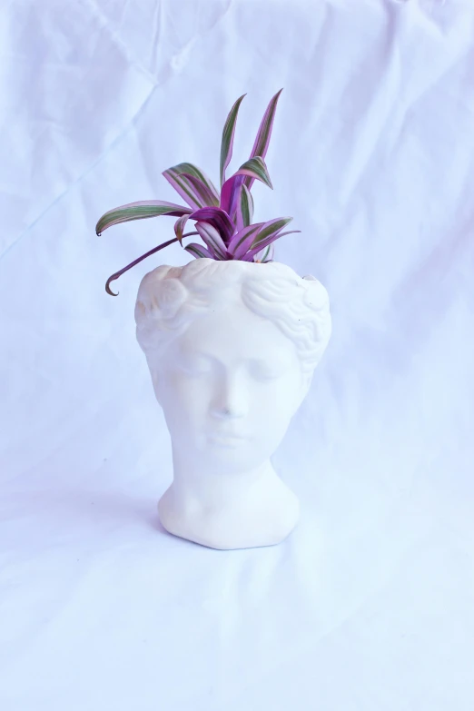 a small sculpture of a woman with purple flowers on her head
