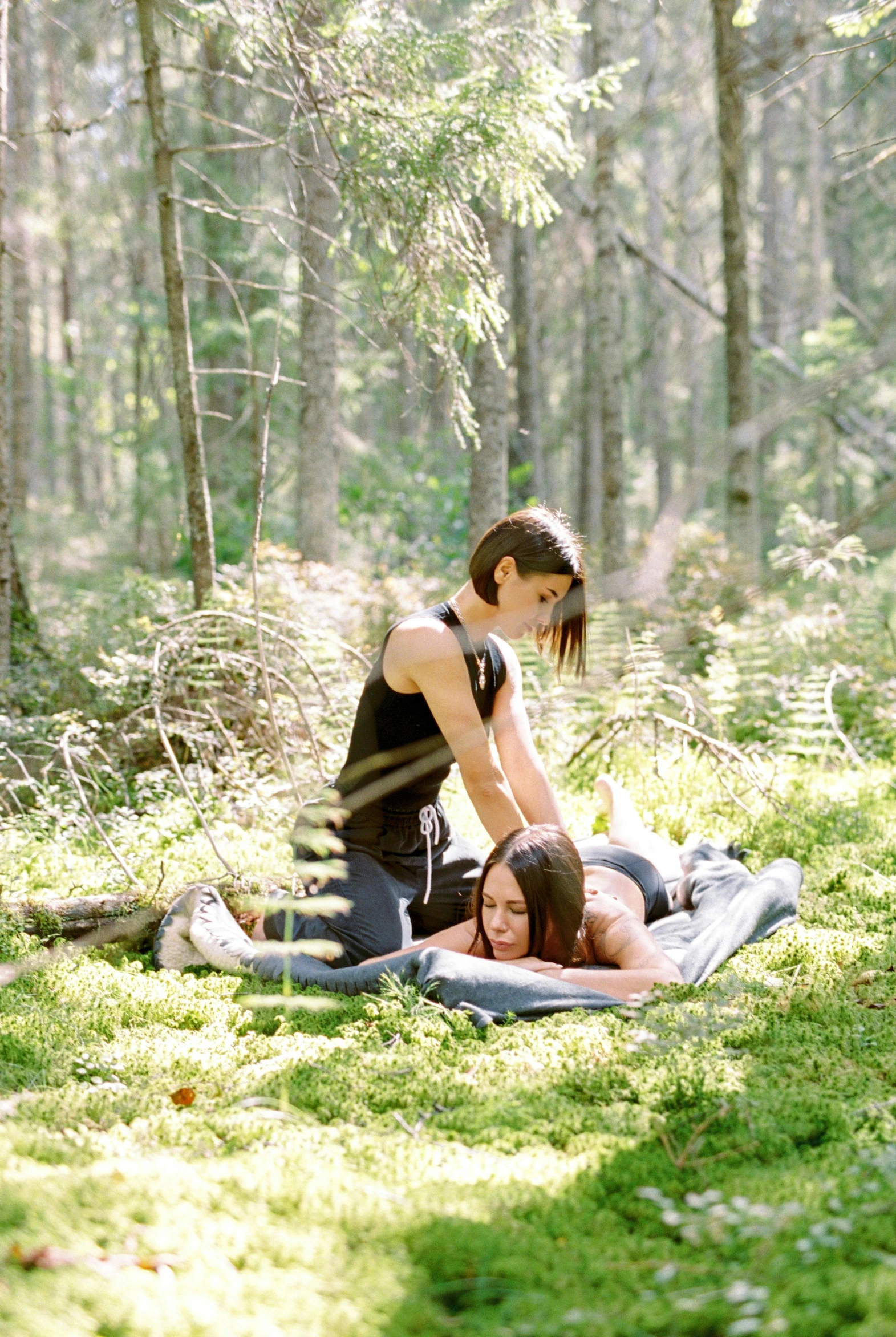 a couple laying on the ground in the forest