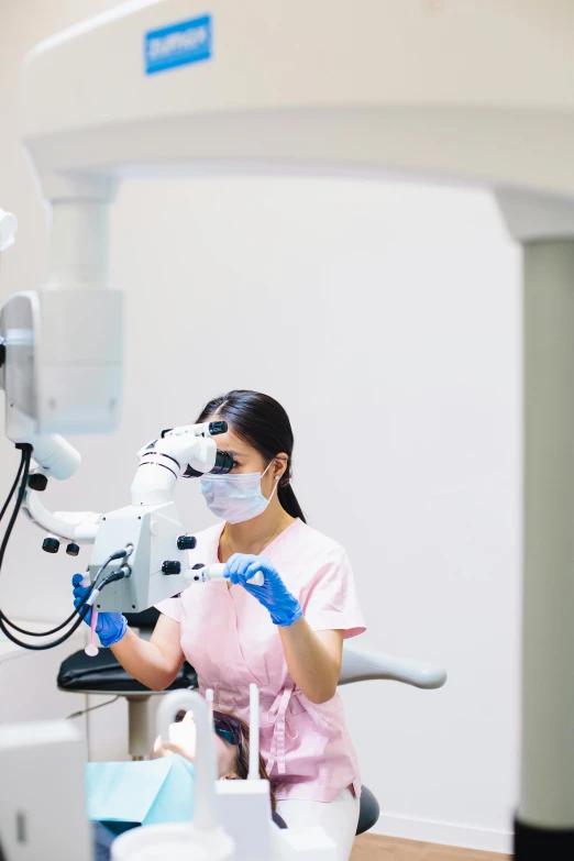 a dental technician is wearing a mask while working on a patient