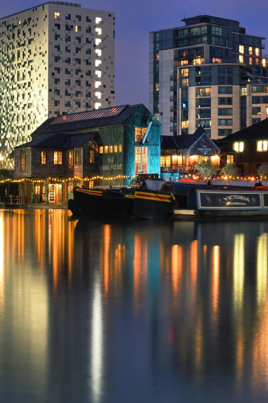 city lights reflect off the water near a harbor