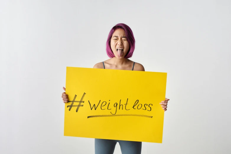 a woman in headbands holding a yellow sign