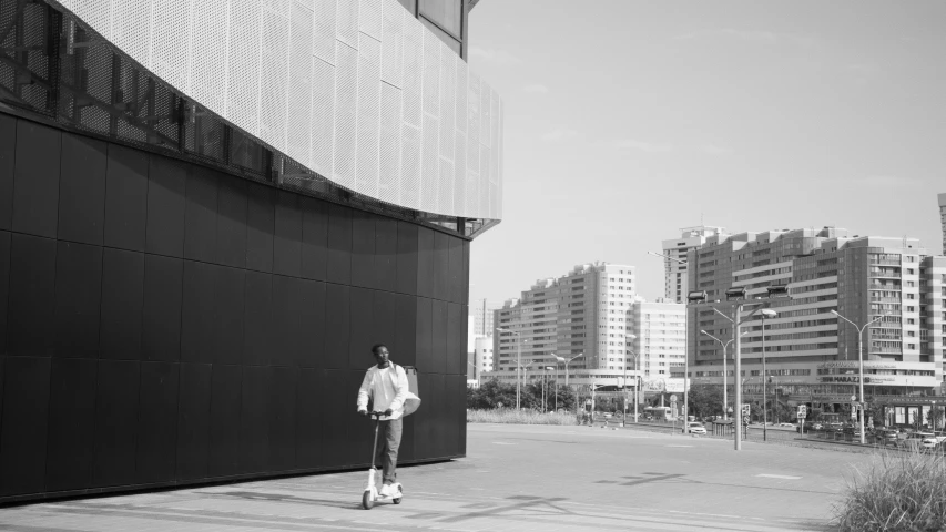 a man is walking along a large wall in the city