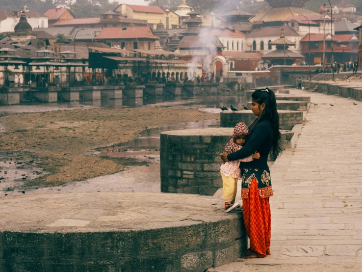 the woman is sitting on the ledge while looking over the town