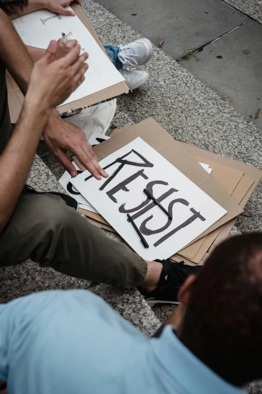 a man on the ground next to a sign with writing