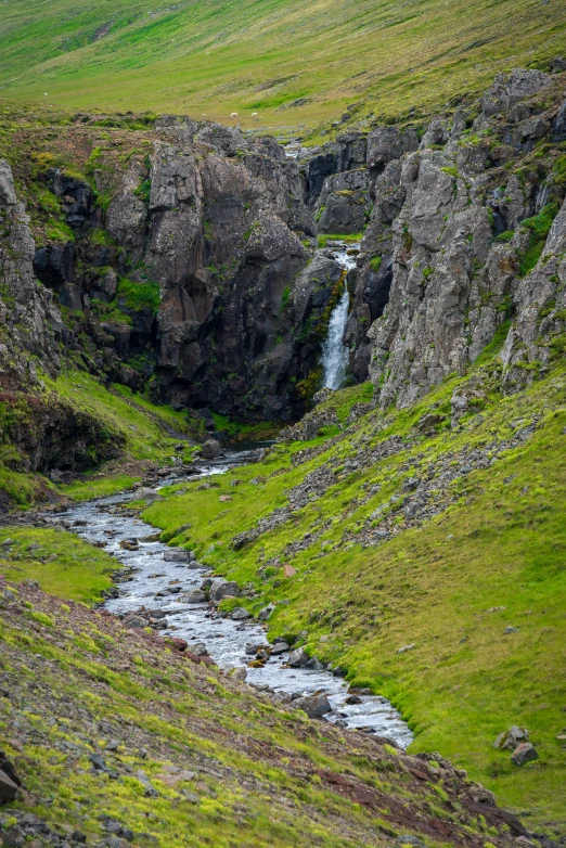 there is a stream that can be seen coming out of the rock