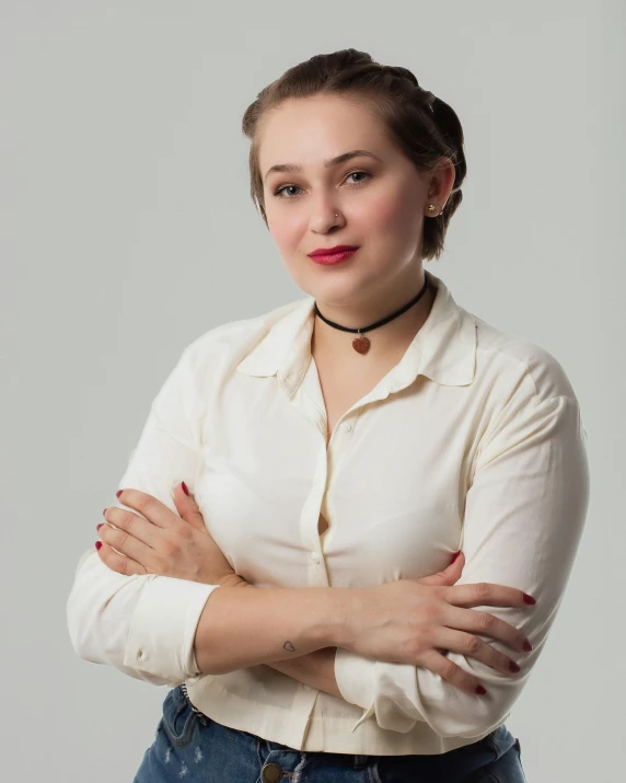 woman with arms crossed posing in denim skirt