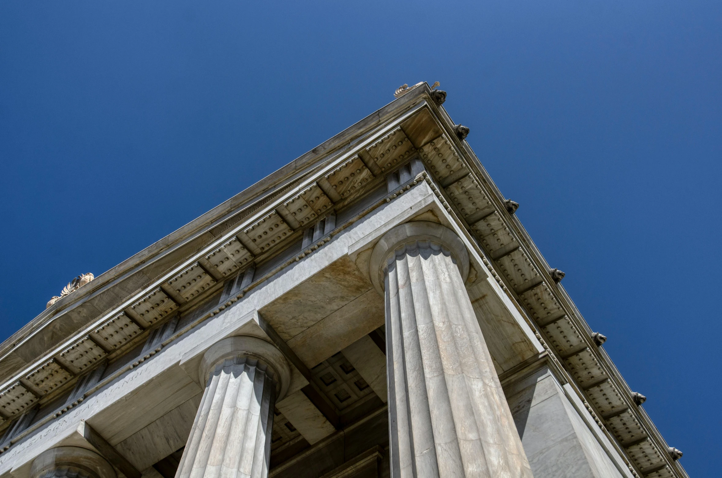 four pillars on the top of two large white buildings