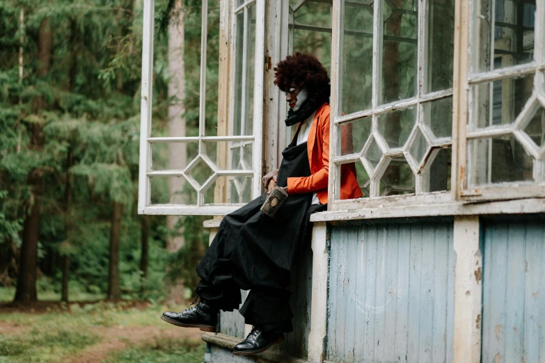 a person sitting on a ledge near a window