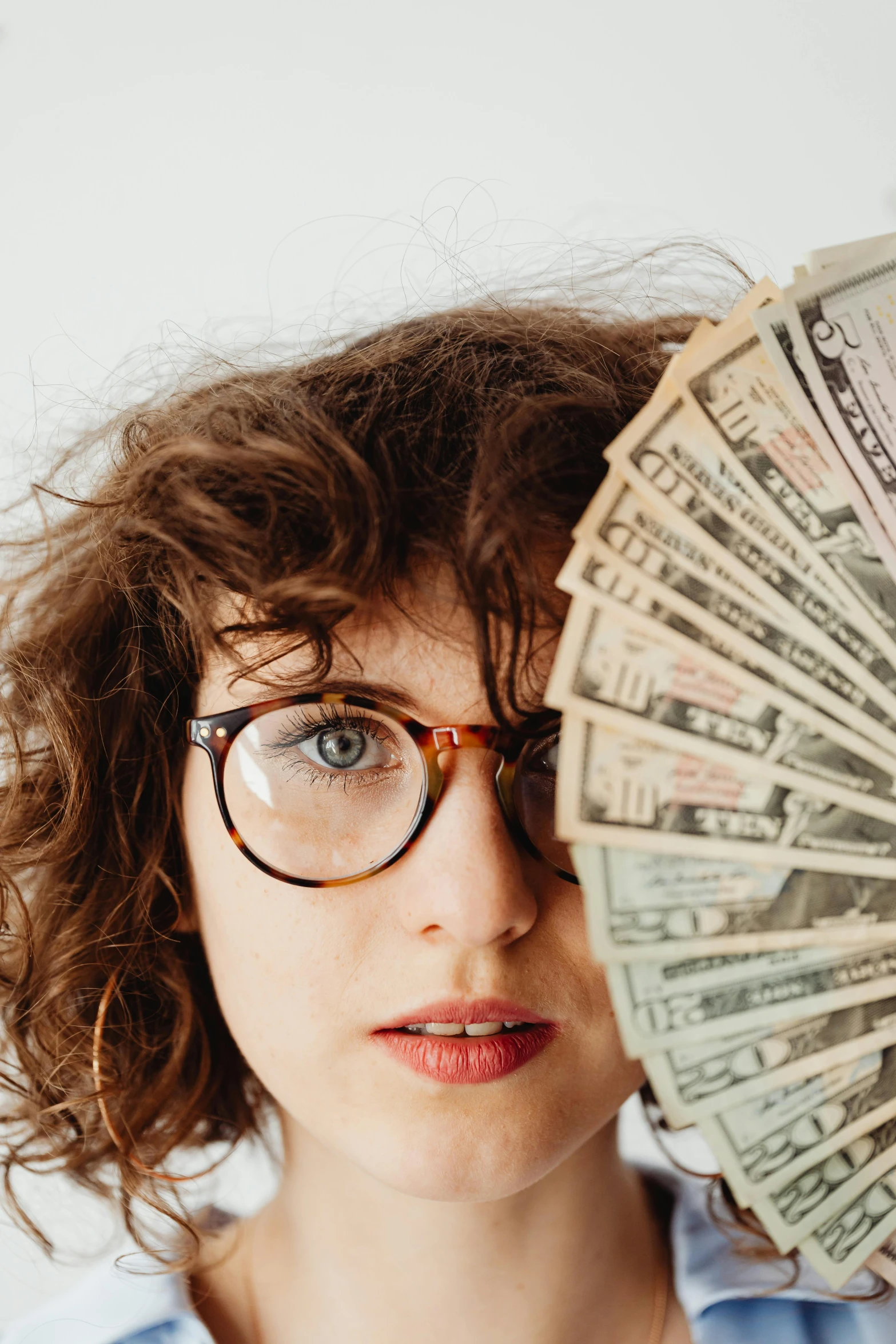 a woman holding her hands on a stack of cash