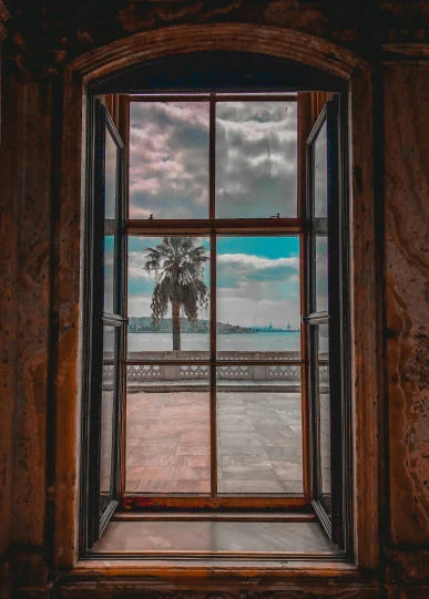 a window that looks out to the sea on a cloudy day