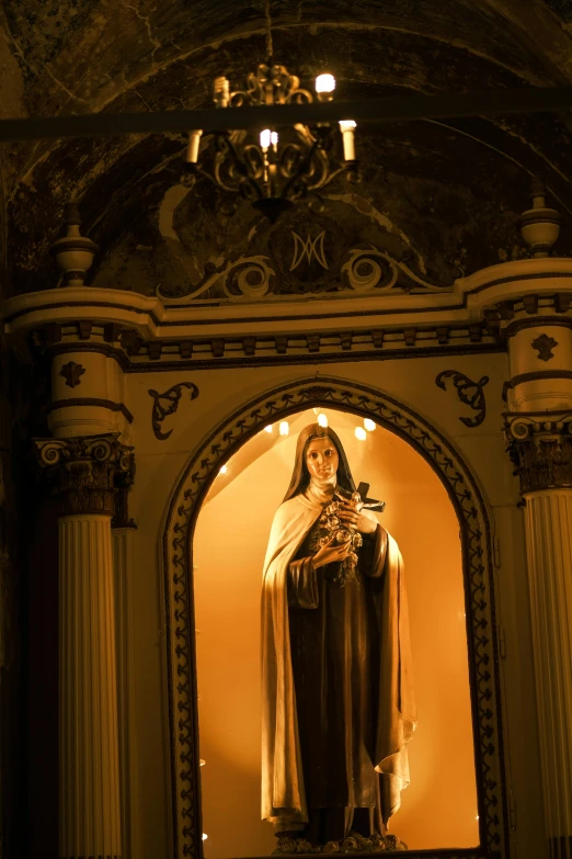 a statue of virgin mary stands in front of an archway