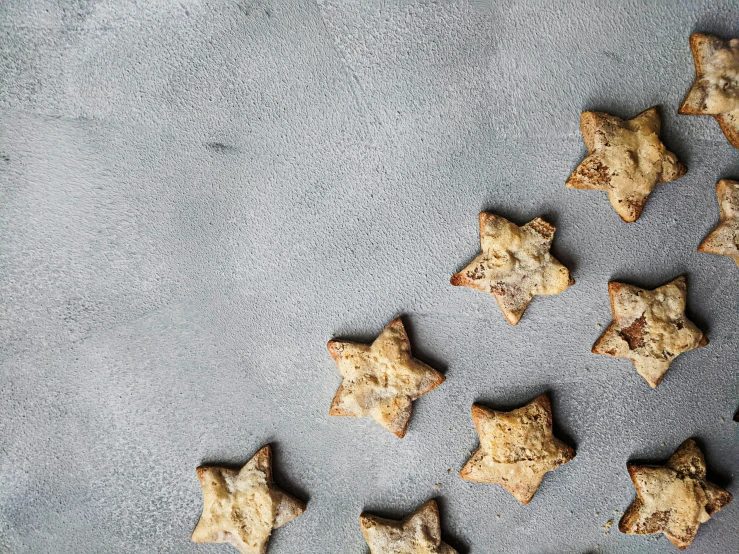 an assortment of baked star shaped cookies on a gray surface