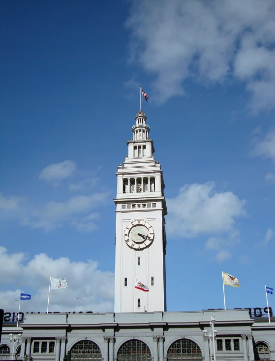 a white clock tower in the middle of a city