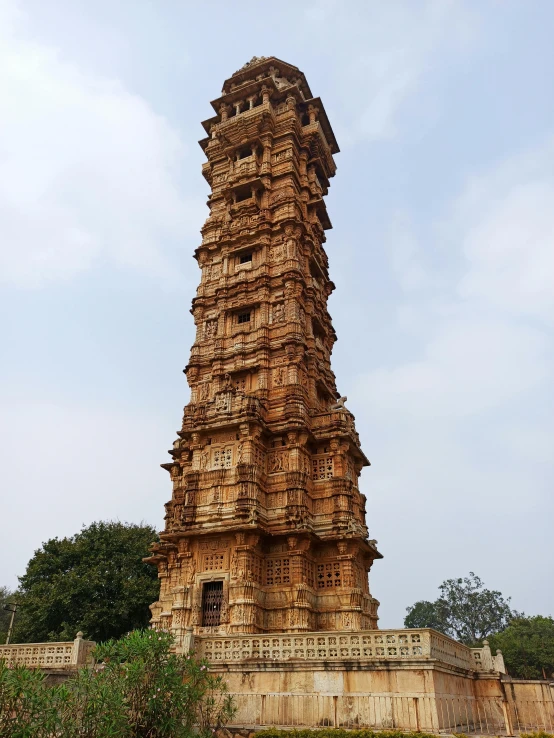 the top of a very tall brown building with a stone wall