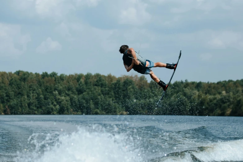 a man doing tricks while water skiing on a lake