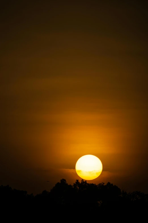 the setting sun seen through clouds, with no light on it