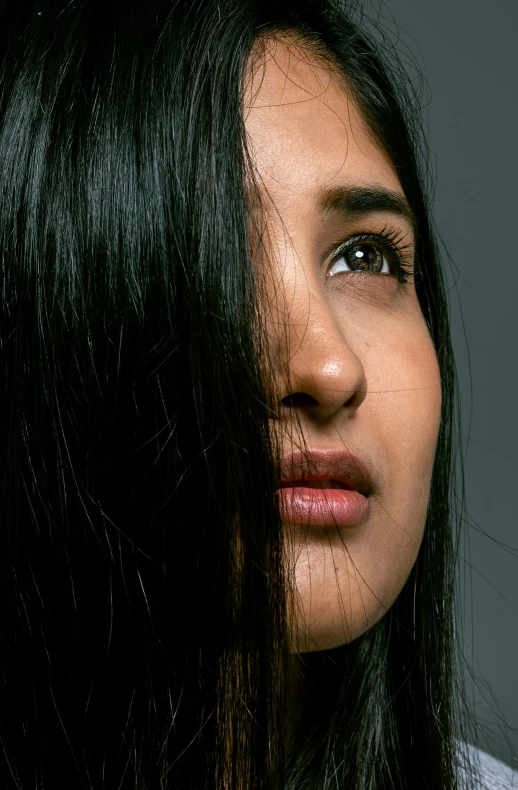 a close - up view of a woman's dark hair and makeup