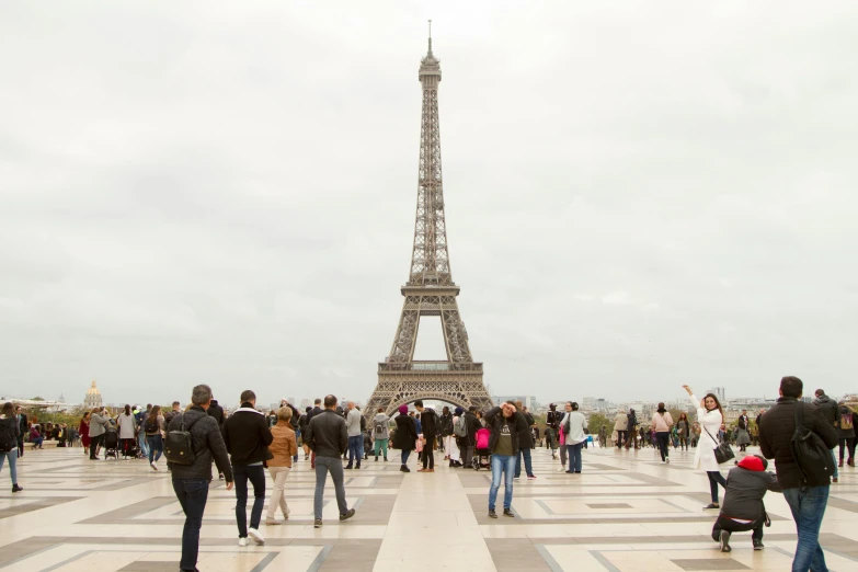 the crowd is all walking around the eiffel tower