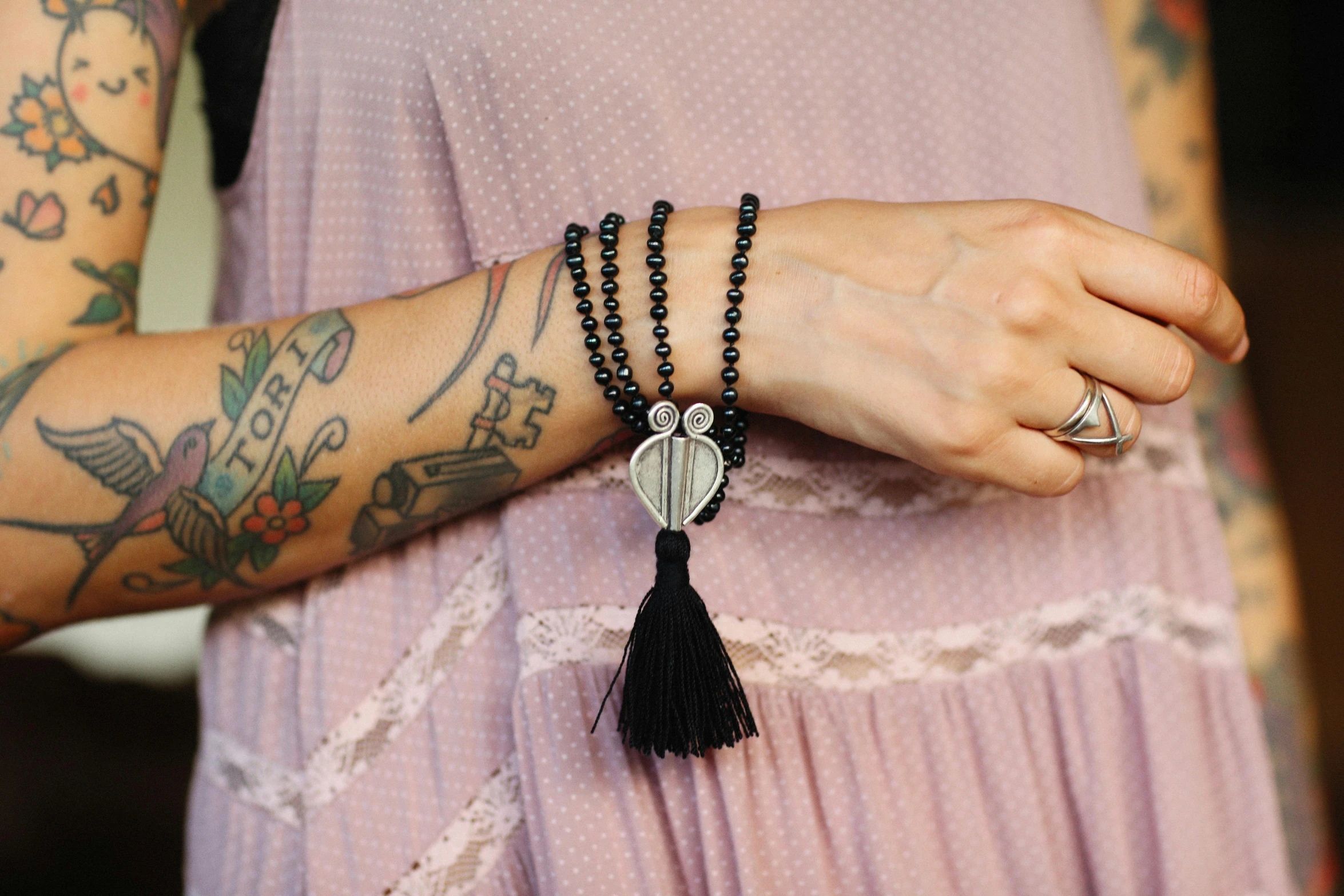 a woman wearing a purple dress holding her tattoo sleeves and arm