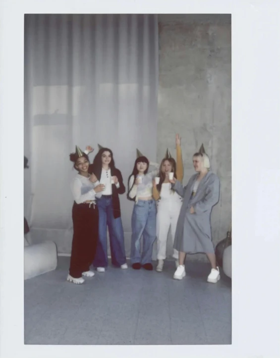 four ladies standing in a line with one wearing a paper crown