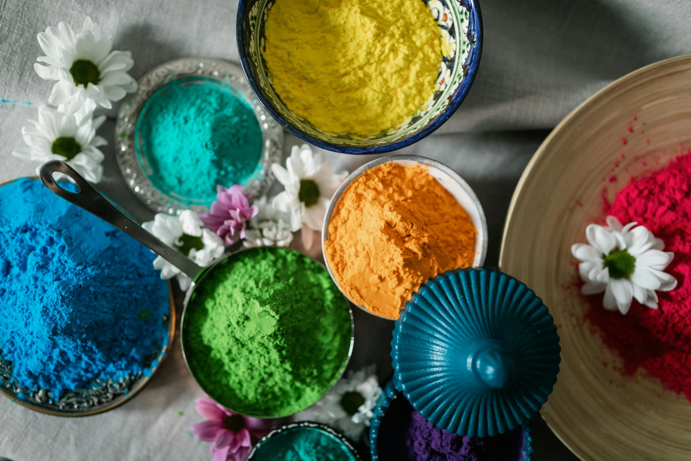 several bowls filled with different colored powders on top of a table