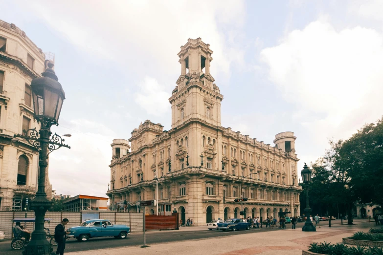 an old building is shown along side some blue cars