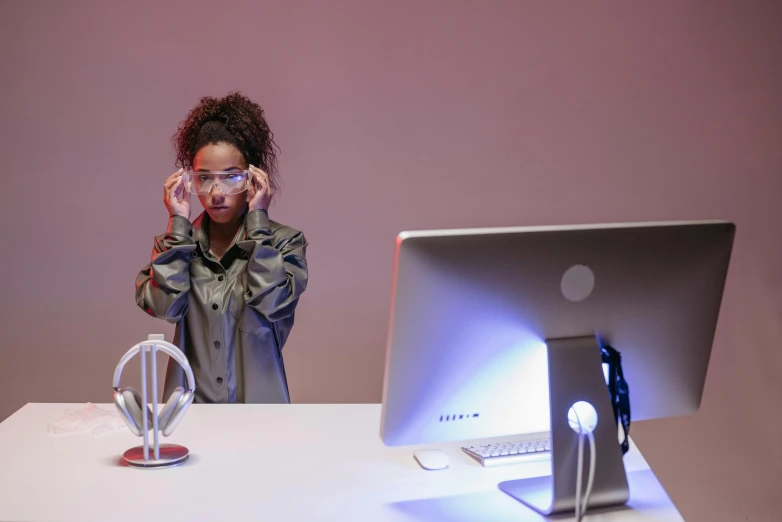 a woman with glasses sitting behind a desk