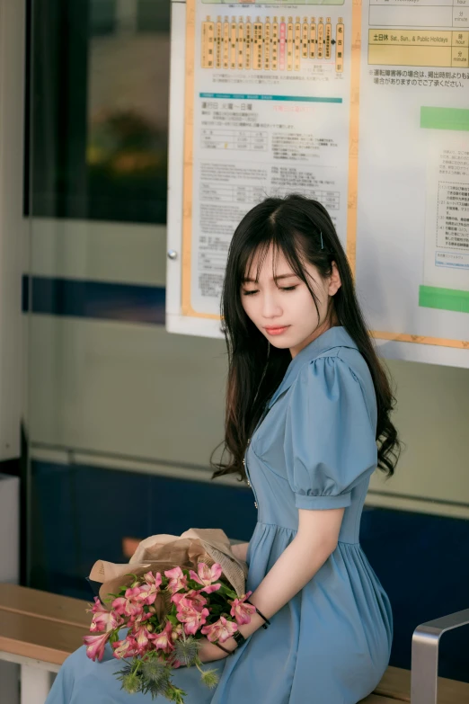 a woman with dark hair holding a bouquet of flowers