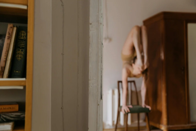 there is a person sitting on a chair near a book shelf