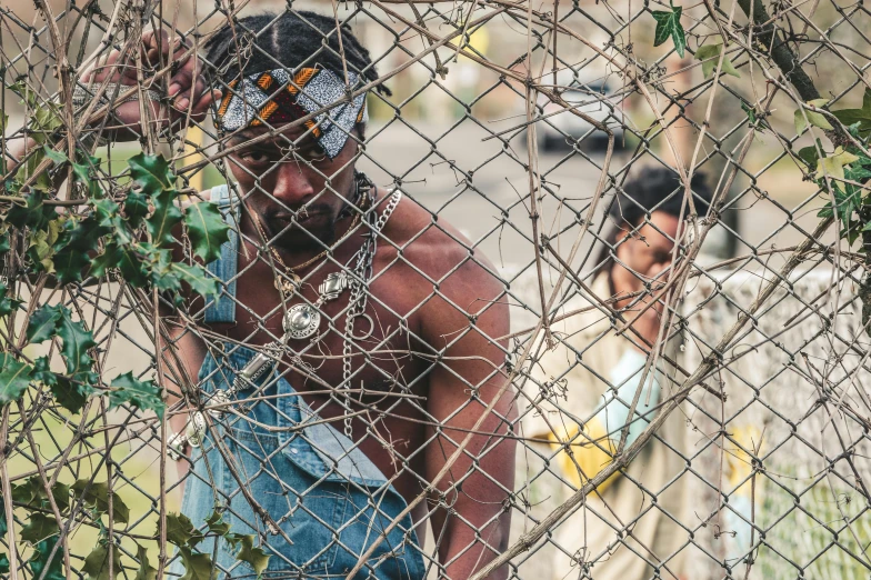 two people behind a barbed wire fence, looking at soing