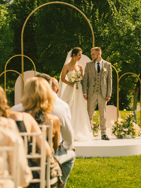 a wedding couple standing under a archway with an archway between them