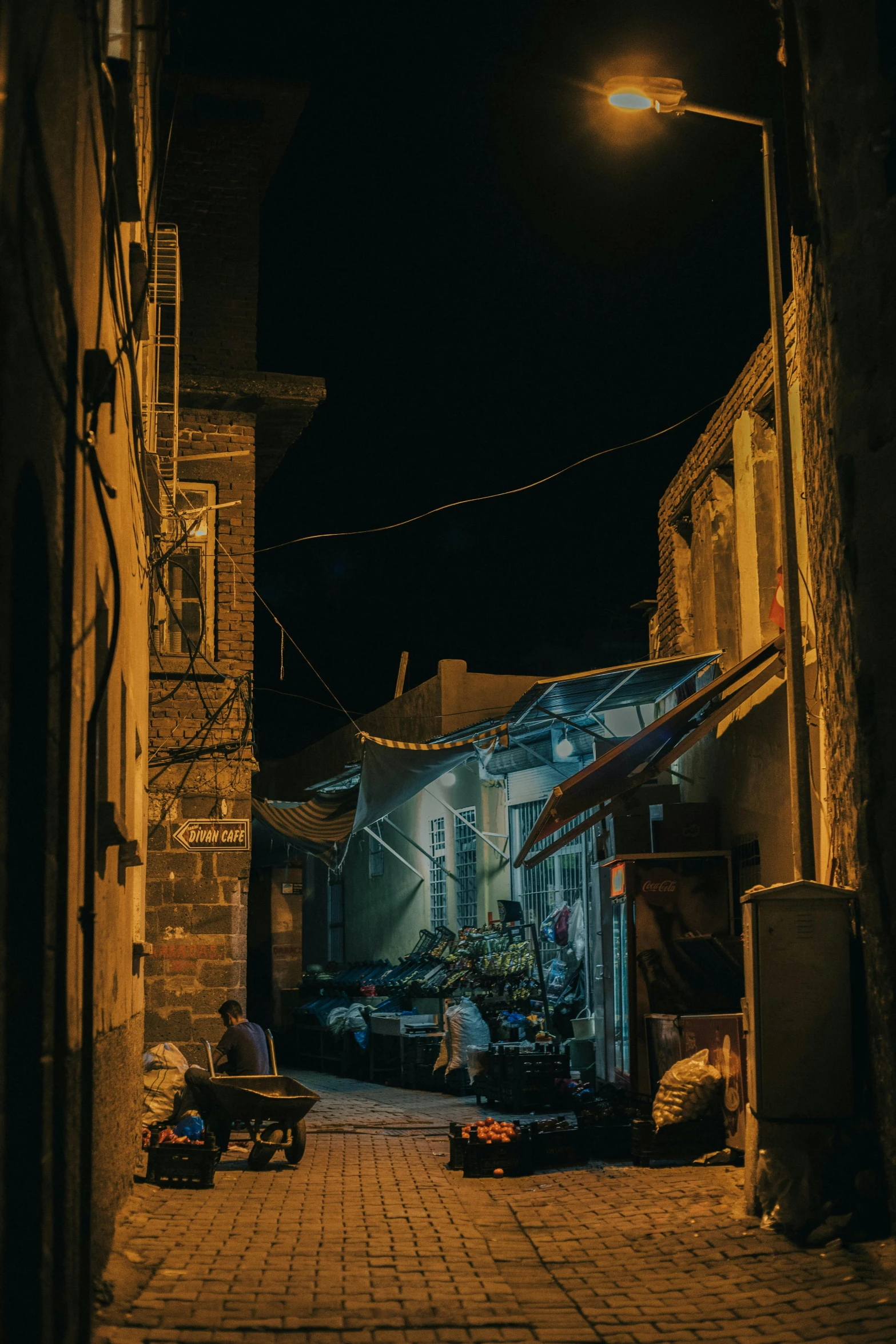 a night scene with a woman sitting in the dark of the alley