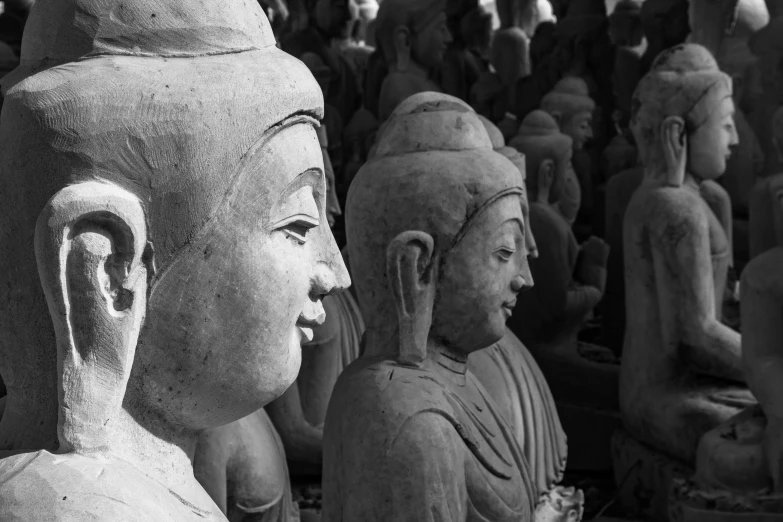 buddha statues line the wall at the entrance of a buddhist temple