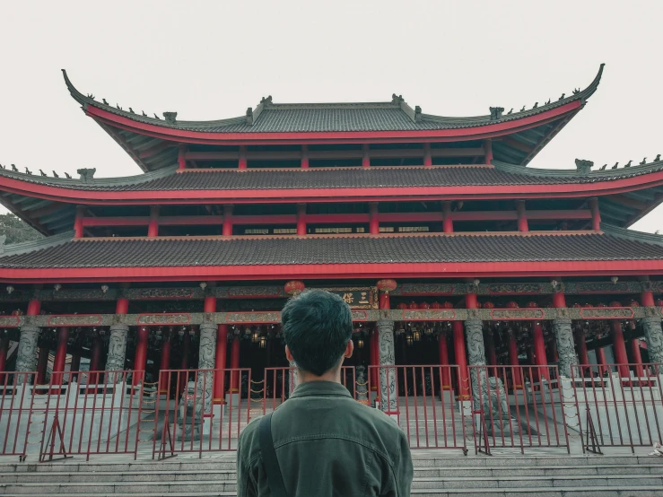 a person with green hair and jacket looking at building