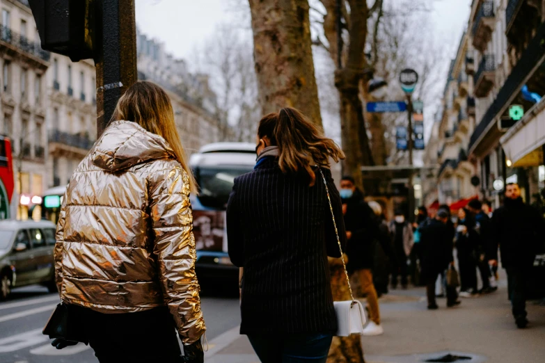 the two women are walking together on the street