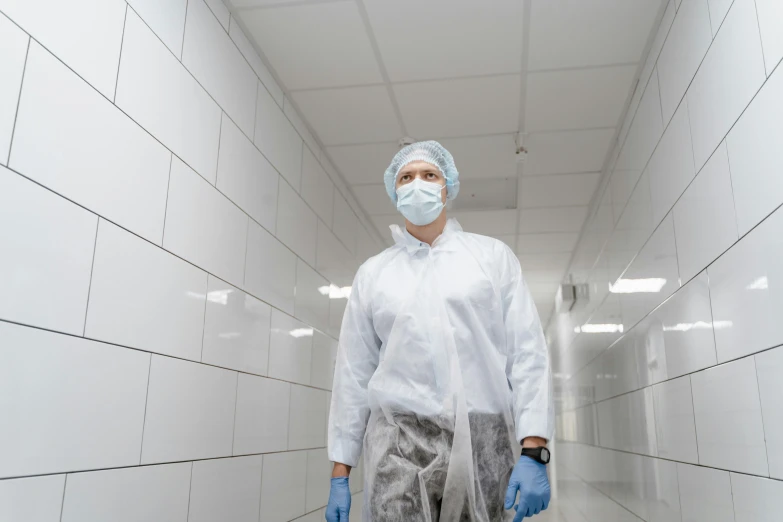 a person in white coat and surgical mask and gloves