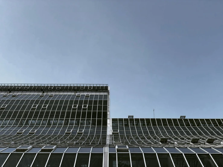 a tall metal and glass building against a blue sky