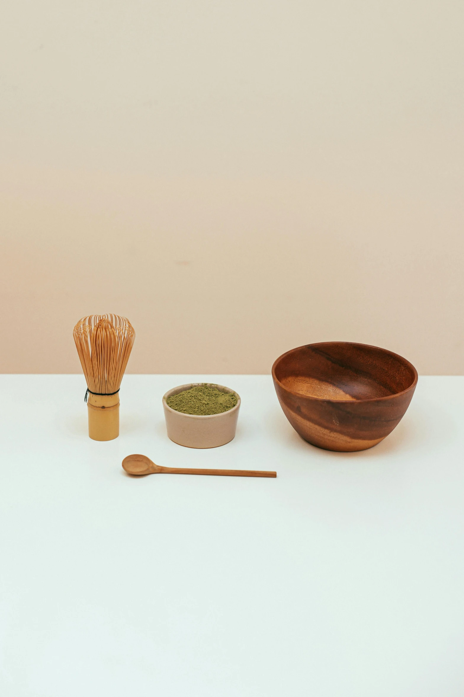 various kinds of food and wooden utensils on a white table